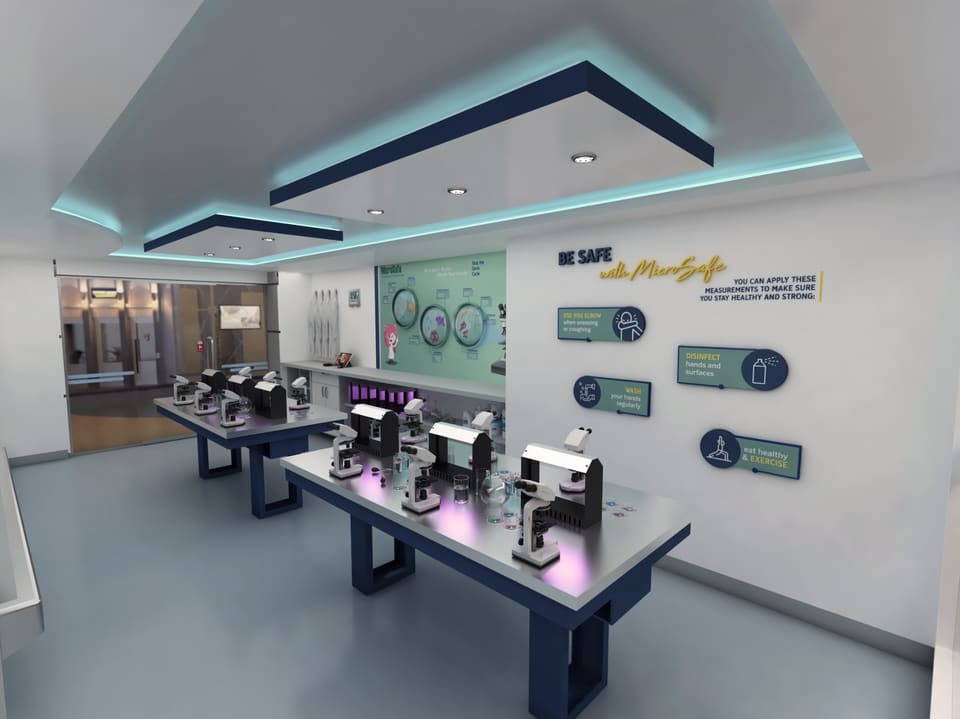 Interior of a modern Downtown Dubai flagship retail showroom with a seamless light-grey poured floor, navy display tables holding product units, a stepped gypsum tray ceiling with turquoise cove lighting and recessed downlights, and a feature wall with dimensional branded graphics.