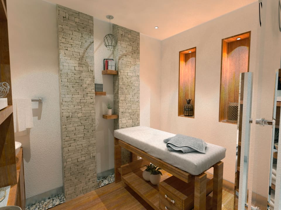 Interior view of a refined corporate space featuring a full-height book-matched stone mosaic feature wall, recessed niche lighting, warm timber accents, a cushioned bench with folded grey towels, pebble-stone flooring detail and a framed wall mirror.